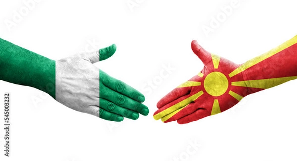 Fototapeta Handshake between North Macedonia and Nigeria flags painted on hands, isolated transparent image.