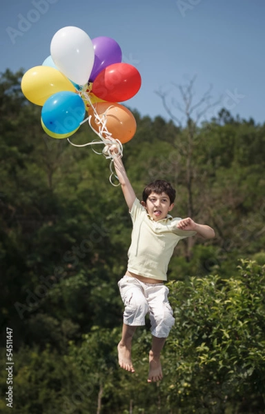 Fototapeta beautiful young man in a spring field with lots of balloons
