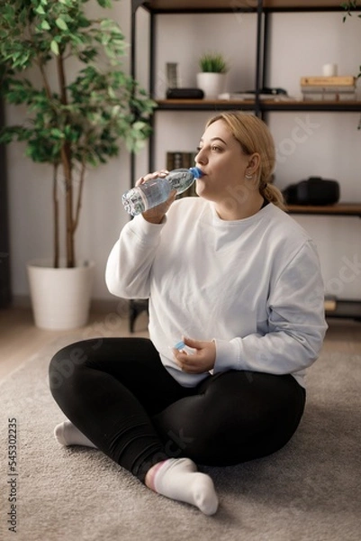 Obraz Woman drinking water after training