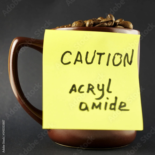 Obraz a mug with roasted coffee beans and a yellow sticker on the mug warning about the presence of acrylamide in it