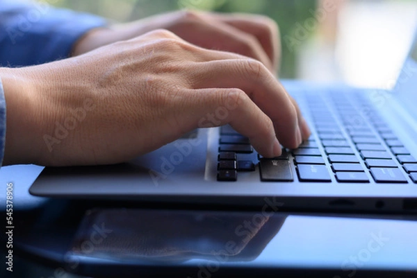 Fototapeta hand tapping keyboard on laptop