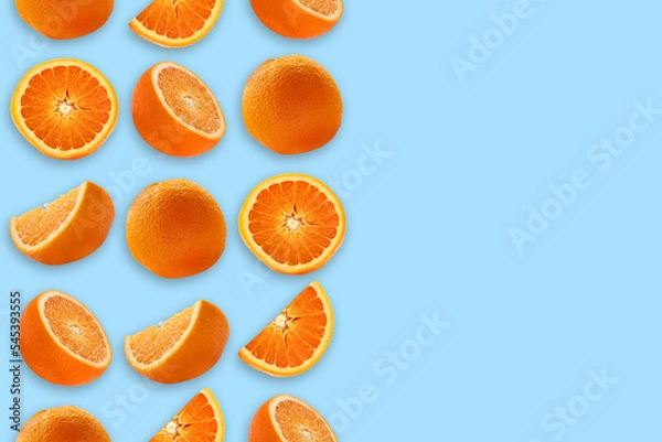 Fototapeta Orange whole and cut on a blue background in three rows with space for text.