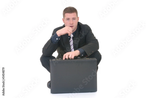 Fototapeta Handsome young businessman, sitting next to  briefcase,  