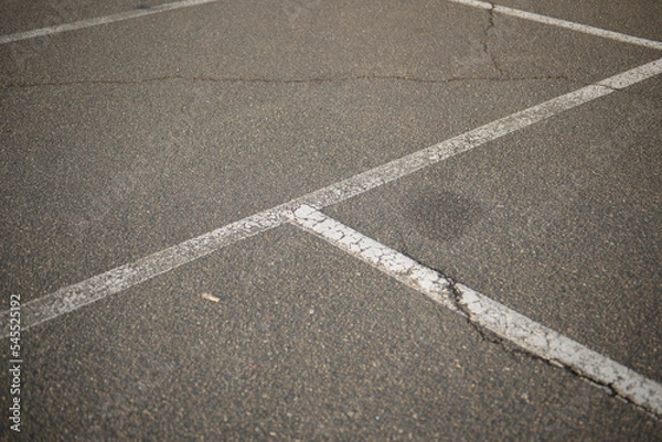 Fototapeta white lines abstract on asphalt, road markings white stripes on the asphalt road, parking spaces separated by white lines, symmetrical abstract lines on gray asphalt