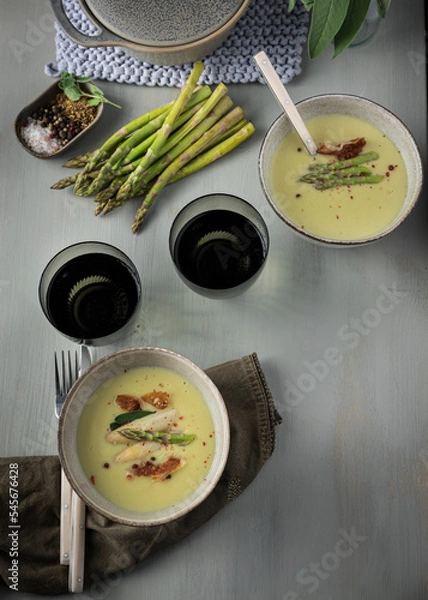 Obraz Two ready to eat asparagus cream soup ceramic bowls in a elegant dinner table.