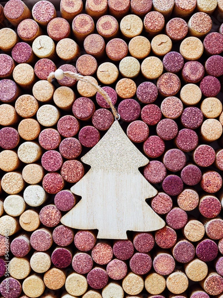 Fototapeta Wine corks with Christmas fir tree wooden toy as copy space, natural texture used bottle stoppers. Christmas background with close up wooden corks. New Year holidays wine concept