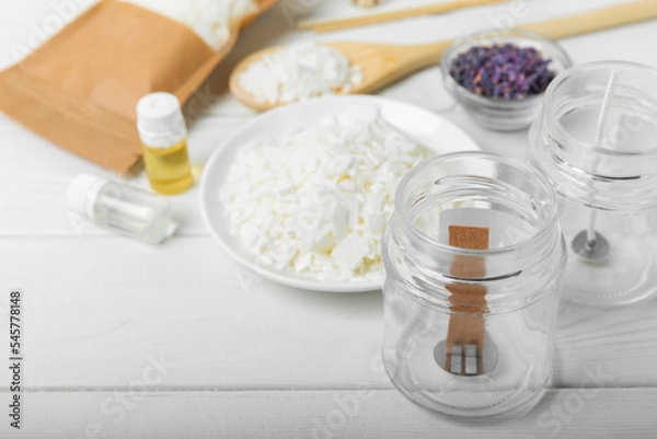 Fototapeta Ecological and vegan handmade soy wax candles with wooden wick. Transparent container, essential oil, soy wax, matches and dried flowers. MOCKUP, space for text. Handmade craft candles.