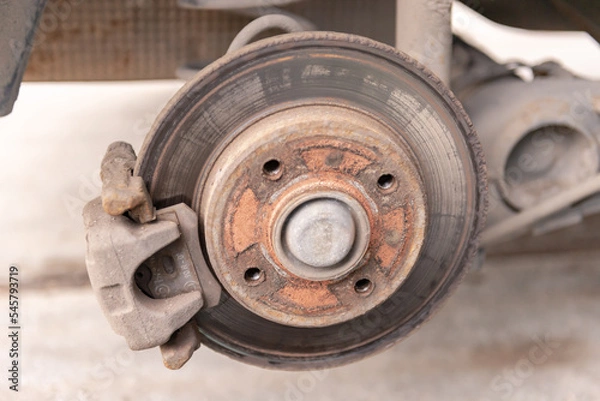 Fototapeta Heavily worn brake disc. Car brake disc after removing the wheel. A rusty disk that needs to be replaced.