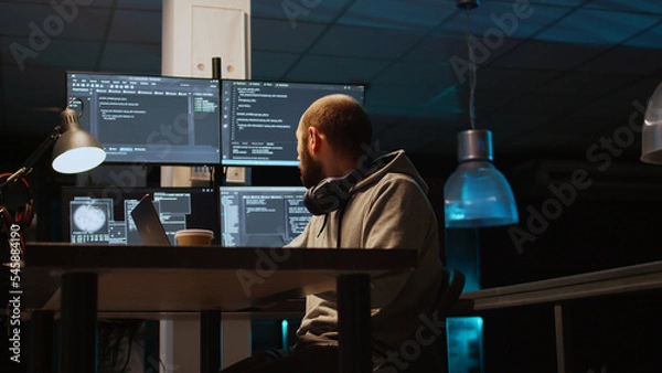 Fototapeta System programmer typing source code on laptop and multiple monitors, using programming language to create firewall security server. Coder developing database cloud computing. Handheld shot.