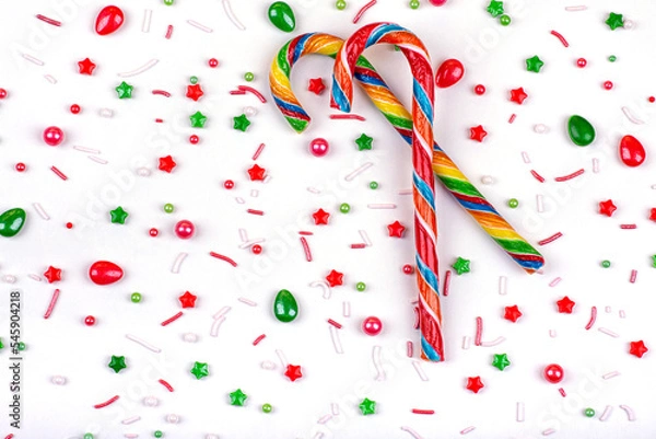 Fototapeta Christmas background of colorful candies, cane lollipops on a white background, close-up