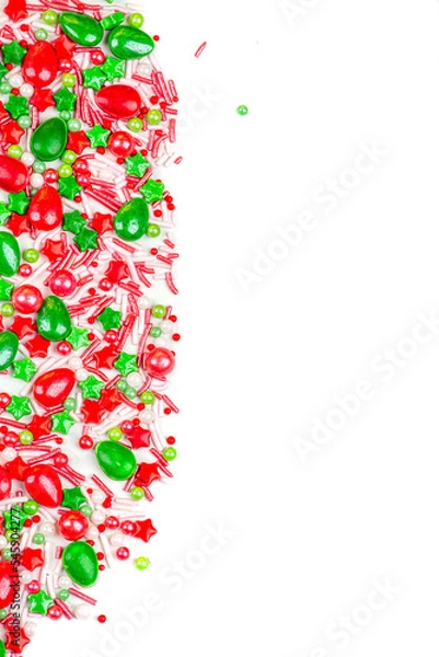 Fototapeta Christmas background of colorful candies. Red and green candies of different shapes on a white background, close-up. copy space.