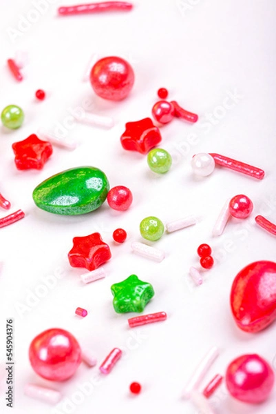 Fototapeta Christmas background of colorful candies. Red and green candies of different shapes on a light background, macro photography
