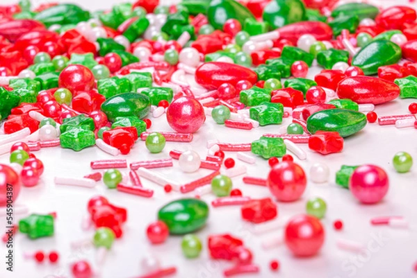 Fototapeta Christmas background of colorful candies. Red and green candies of different shapes on a light background, macro photography