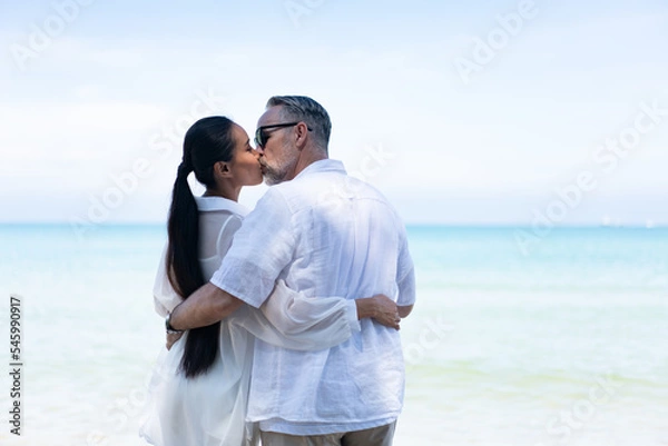Fototapeta Romantic Couple Walking on the Beach. portrait of living young couple at the beach. Romantic marriage proposal at the seaside on the beach sea. Romantic marriage proposal on the beach.