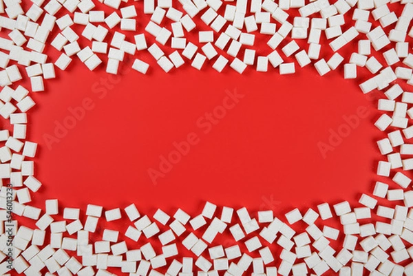 Fototapeta Frame made from sugar cubes on red background with a copy space