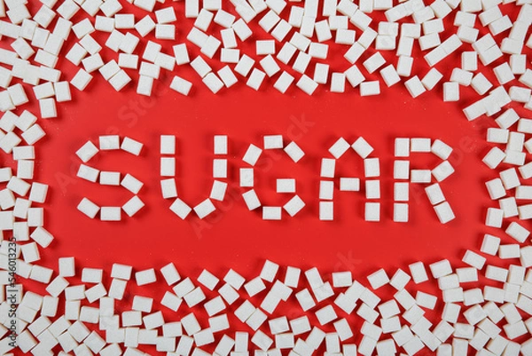 Fototapeta Sugar word and a frame made from sugar cubes on red background