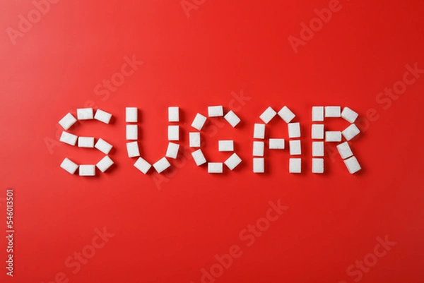 Fototapeta Sugar word made from sugar cubes on red background