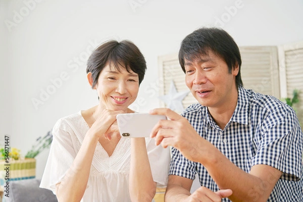 Fototapeta 家でスマホを見る熟年夫婦