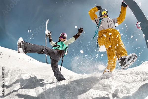 Obraz Happy couple of snowboarders are having fun and jumps with snowboards in hands. Winter holidays at ski resort