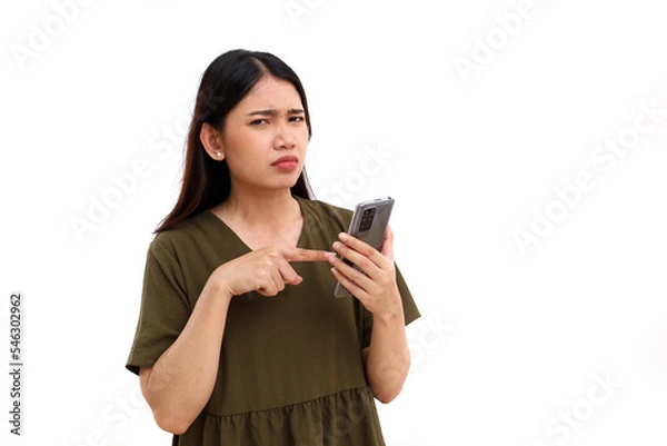 Obraz Unhappy expression of young asian woman with her phone. Isolated on white background with copyspace