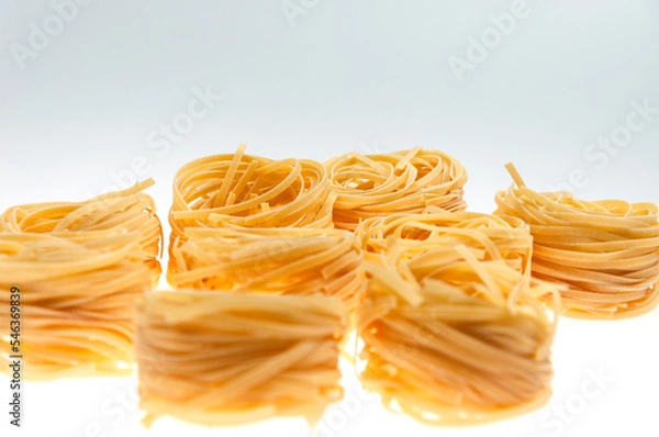 Fototapeta Pasta in the form of nests on a white background close-up.
