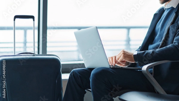 Obraz business man using his laptop during a business trip.