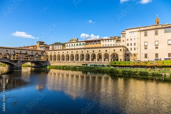 Fototapeta Florence, Italy. Arcade on the embankment of the Arno River and the Ponte Vecchio bridge - a fragment of the Vasari corridor (Corridoio Vasariano), 1565