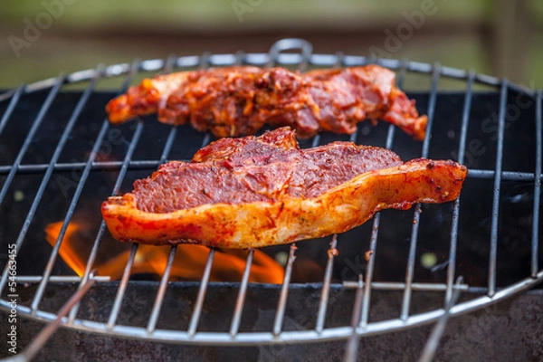 Obraz Flames grilling a steak on the BBQ