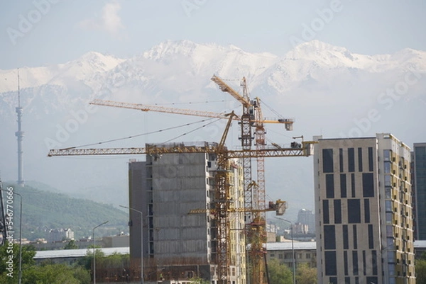 Fototapeta Almaty, Kazakhstan - 04.26.2022 : Construction of a high-rise residential complex near a road junction.