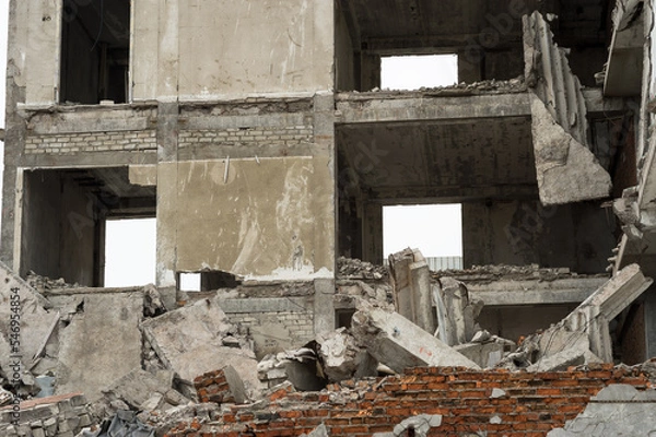 Obraz A destroyed building in close-up with a pile of concrete debris, slabs and piles in the foreground. Background