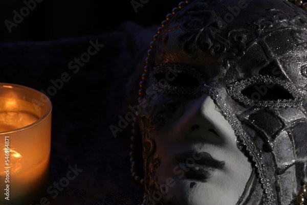 Obraz Carnival mask arranged with the burning candle on the black background 
