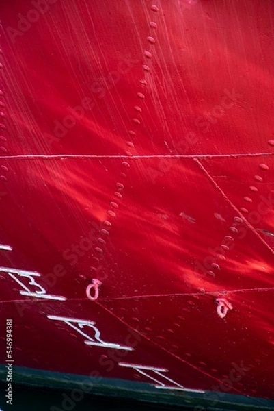 Fototapeta Side of a ship showing the construction of the hull in red with depth gauge and rivets