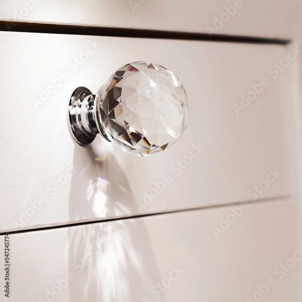 Obraz Close-up of acrylic drawer pulls with selective lighting over them. Part of a white bed table