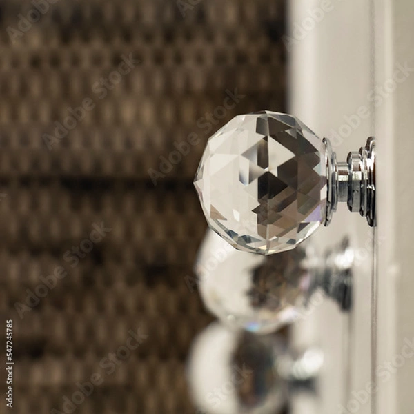 Obraz Close-up of acrylic drawer pulls with selective lighting over them. Part of a white bed table