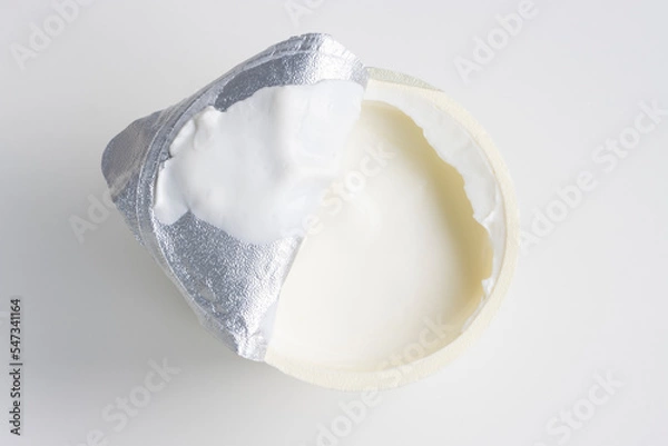 Obraz Top view of an open yogurt cup isolated on a white background. Plain full-fat sheep milk yogurt.