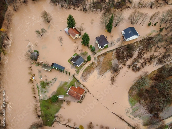 Fototapeta Flooded village, fields, farms and houses, aerial drone view. Aftermath of devastating river flood and landslide. Catastrophic floods. Overflowing river, view from above.	