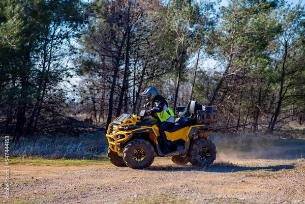 Fototapeta Girl driving ATV on dirt road