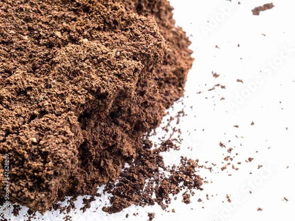 Fototapeta Ground coffee powder isolated on white background..Used coffee grounds after espresso machine and coffee beans on white  background.Caffeine addiction concept.