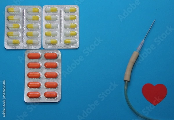 Obraz treatment of cardiac diseases, tablets in a blister on a blue background