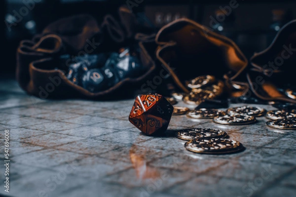 Fototapeta Red RPG die on a gaming grid with game coins and dice bags