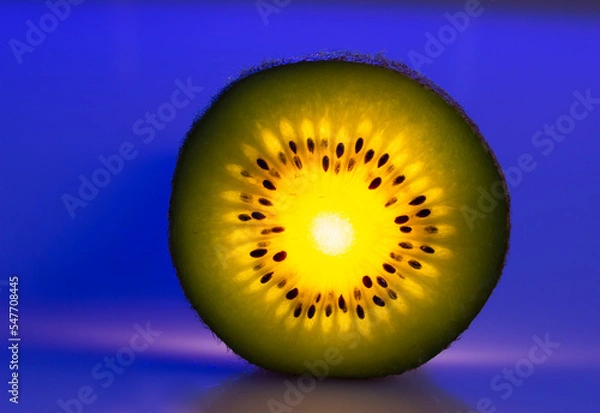 Obraz glowing kiwi slice on blue background
