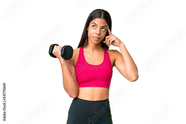 Fototapeta Young African American woman sport woman making weightlifting over isolated chroma key background having doubts and thinking