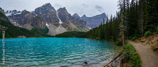 Obraz Panoramic view of Moraine Lake in a cloudy summer afternoon from the footpath by the lake.