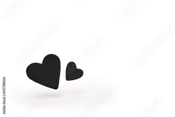Fototapeta Two black hearts floating isolated on white background.