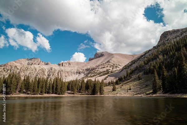 Fototapeta Stella Lake, an alpine lake located within Great Basin National Park in Nevada seen on a summer day. Wheeler Peak is visible in the background. The sky is filled with white cumulus clouds.
