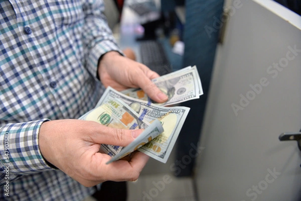 Fototapeta  Cash in hands. Profits, savings. Stack of dollars. Man counting money. Dollars in man's hands. Selected Focus