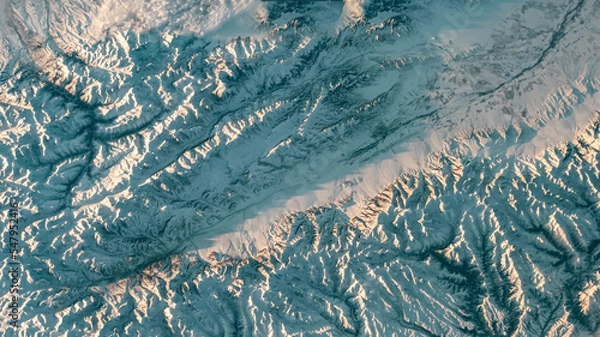 Fototapeta Aerial view of mountain landscape. Snow covered mountains winter background. Earth landscape view in winter. Earth observatory from satellite. Elements of this image furnished by NASA
