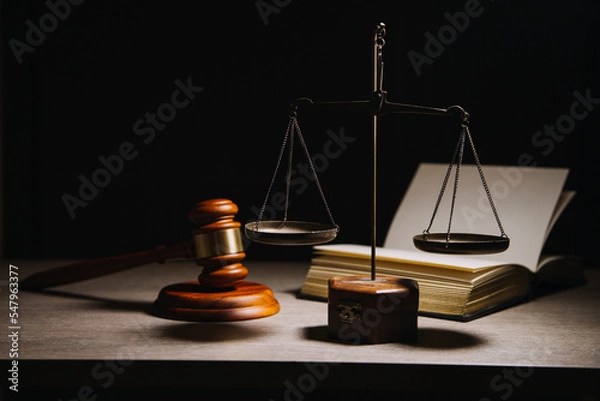 Obraz Justice and law concept.Male judge in a courtroom with the gavel, working with, computer and docking keyboard, eyeglasses, on table in morning light