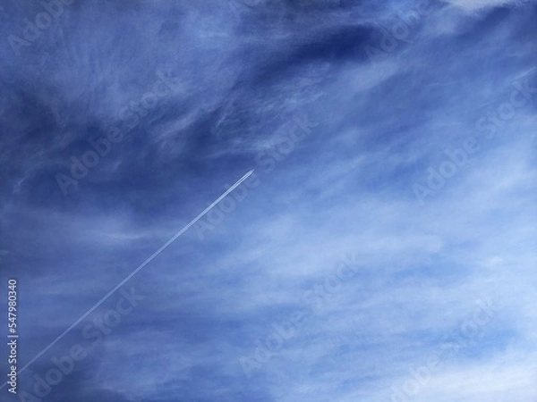 Fototapeta Airplane with jet stream in the clouds