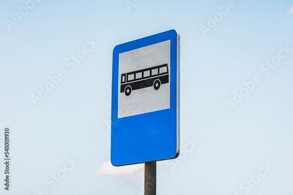 Fototapeta Close-up to a blue and white rectangular bus stop sign against clear sky
